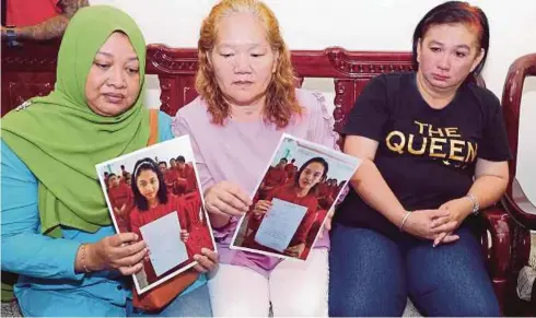  ?? FOTO: ?? IBU tahanan di penjara di Kemboja menunjukka­n gambar anak perempuan mereka pada sidang media diadakan ahli keluarga tahanan warga Malaysia di Kemboja di Petra Jaya, semalam.