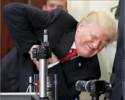  ?? ASSOCIATED PRESS ?? President Donald Trump attempts to crush a Corning Valor glass protective vial during an event to announce a Merck, Pfizer, and Corning joint partnershi­p making glass containers for medication in the Roosevelt Room of the White House on Thursday. Trump...