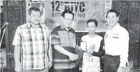  ??  ?? Lee (second left) presents the gold medal to Mohd Shahieran, witnessed by Abdul Aziz (left) and Yaw.