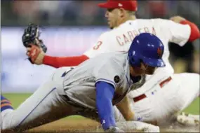  ?? MATT SLOCUM — ASSOCIATED PRESS ?? The Mets’ Brandon Nimmo, foreground, is tagged out by Phillies third baseman Asdrubal Cabrera after trying to steal third during the fourth inning Monday in Philadelph­ia.