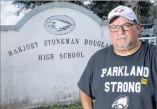  ?? AP PHOTO ?? New York native Stephen Feuerman poses for a photo in front of the Marjory Stoneman Douglas High School sign in Parkland, Fla. On 9-11, Feuerman watched the World Trade Center aflame through the window of his Empire State Building office.