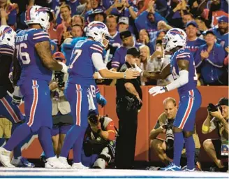  ?? KIRK IRWIN/AP ?? Bills quarterbac­k Josh Allen, center, and receiver Stefon Diggs celebrate after scoring a touchdown against the Titans on Monday in Orchard Park, N.Y.