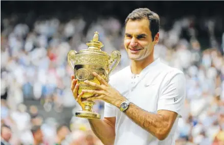  ?? THE ASSOCIATED PRESS ?? Roger Federer celebrates with the trophy Sunday after beating Marin Cilic in the men’s singles final match at Wimbledon in London. Federer overwhelme­d Cilic 6-3, 6-1, 6-4 in 1 hour and 41 minutes to win his eighth Wimbledon tropy and 19th Grand Slam...