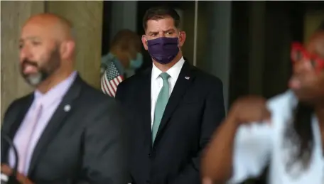  ?? pOOL pHOTO ?? ‘BE VERY CAREFUL’: Mayor Martin Walsh, seen listening to Health and Human Services chief Marty Martinez on Thursday at City Hall, says coronaviru­s cases are ‘trending much younger.’