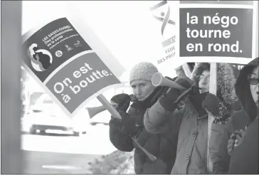  ?? GORDON LAMBIE ?? A small group of protesters braved the cold in the shadow of the building housing Luc Fortin's Riding offices on Monday to make their concerns about working conditions for Quebec's midwives heard.