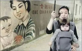  ?? Amazon Studios ?? NANFU WANG, with her son, is a co-director of “One Child Nation.” She has a younger brother because of an exception to the Chinese policy for rural families.