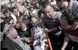  ?? — AP ?? Palestinia­ns carry an injured protester during clashes with Israeli security forces on the Gaza- Israel border following a protest calling for the right to return, east of Gaza City on Friday.