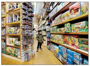  ?? AP/RICHARD DREW ?? A young customer checks out the goodies at New York City’s Mary Arnold Toys, which offers a personal touch for shoppers.