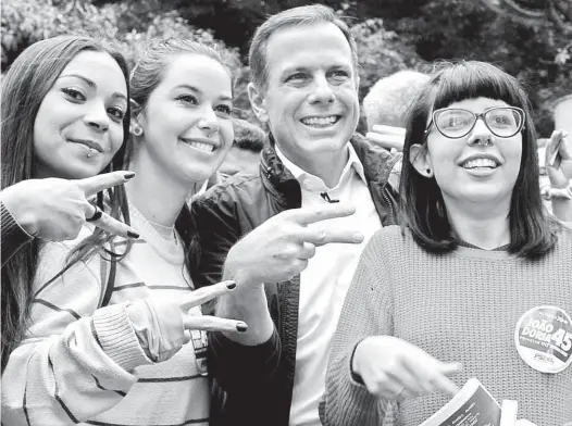  ?? Daia Oliver/Folhapress ?? O candidato a prefeito de São Paulo João Doria (PSDB) encontra eleitoras na avenida Paulista (região central de SP), no último dia de campanha; com maior tempo de campanha na TV e desenvoltu­ra diante das câmeras, ele cresceu nas pesquisas de intenção...