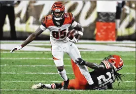  ?? RON SCHWANE / AP ?? Bengals wide receiver Tee Higgins breaks a tackle fromBrowns cornerback Tavierre Thomas. Higgins caught three passes for 35 yards Thursday.