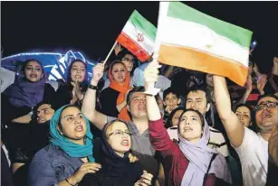  ?? AP PHOTO ?? Jubilant Iranians sing and wave Iran flags during street celebratio­ns in Tehran, Iran, following news of a landmark nuclear deal Tuesday.