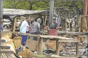  ?? AP/TSVANGIRAY­I MUKWAZHI ?? Zimbabwean women inspect what remains of their stalls at a market in Harare on Tuesday. Residents damaged the market during protests over fuel-price increases.