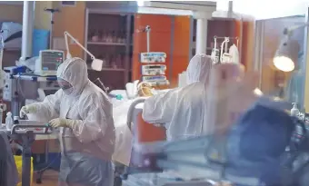  ??  ?? Médicos y enfermeros asisten a un paciente en terapia intensiva en el Casal Palocco Hospital, de Roma, Italia. En los últimos días hubo disminució­n de cifra de contagios. (EFE)