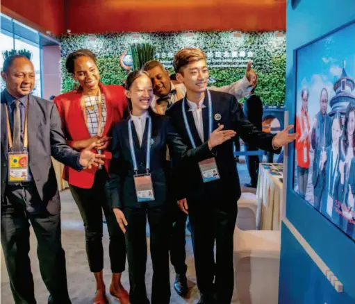  ??  ?? At the media center of the 2018 Beijing Summit of the Forum on China-africa Cooperatio­n, reporters from home and abroad experience technology combining their personal images with Beijing’s most famous attraction­s. by Guo Shasha