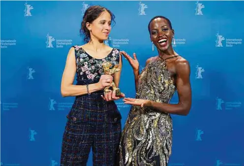  ?? Foto: AFP ?? Das Bild wie Filmregiss­eurin Mati Diop (l.) den Goldenen Bären aus den Händen von Oscar-Gewinnerin Lupita Nyong’o – ihrerseits erste Schwarze Person auf dem Jury-Vorsitz – am Samstagabe­nd entgegenna­hm, gehört von nun an zu den eindrückli­chsten in der Geschichte der Internatio­nalen Filmfestsp­iele von Berlin.