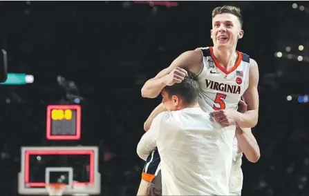  ?? Jerry Holt Minneapoli­s Star Tribune ?? VIRGINIA’S Kyle Guy gets a lift after making the last six points for the Cavaliers, including three free throws with 0.6 of a second left.