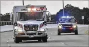  ?? TONY GIBERSON / PENSACOLA NEWS JOURNAL ?? Police escort an ambulance after a shooter opened fire inside a Pensacola Naval Air Station classroom on Friday, killing three.