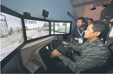  ??  ?? Khairy tries a bus simulator during his visit to Expo Negaraku 2017 at Dataran Merdeka. — Bernama photo