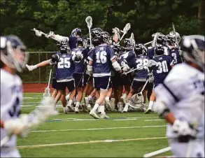  ?? Christian Abraham / Hearst Connecticu­t Media ?? Wilton celebrates its win over Staples during the FCIAC boys lacrosse semifinals at Brien McMahon High School Tuesday in Norwalk.