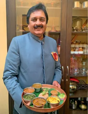  ??  ?? Maharaja Pushpraj Singh of Rewa holds up a Bagheli thali. Below: A plate of Indrahar without the gravy.
Opposite: Spicy chicken biryani in a bowl.