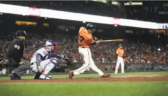  ?? Ezra Shaw / Getty Images ?? Kelby Tomlinson hits an RBI double in the seventh, part of a Giants rally that saw Gorkys Hernandez score from third when the Dodgers’ Pedro Baez fell off the mound and balked.