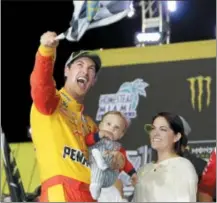  ?? TERRY RENNA - AP ?? Joey Logano waves the checkered flag as he stands with his wife Brittany Baca and son Hudson after winning NASCAR Cup Series Championsh­ip at the Homestead-Miami Speedway, Sunday, in Homestead, Fla.