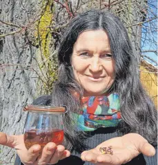  ?? FOTO: MARTINA DIEMAND ?? Annette Kienzler vor einer Linde bei ihrem Gemüsehof in Frohnhofen: Die Knospen kann man gut essen, sie wirken besänftige­nd. Links ist eine Knospentin­ktur zu sehen. Allerdings nicht von der Linde, denn die wäre recht schleimig.