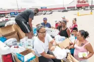  ?? Jon Shapley / Houston Chronicle ?? People line up for free barbecue prepared by “House of Hoops BBQ” near a storm-shuttered Fiesta Mart.