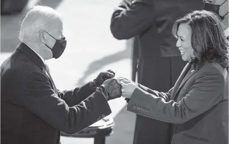  ?? DREW ANGERER Getty Images ?? Joe Biden fist-bumps newly sworn-in Vice President Kamala Harris at the Capitol in Washington, D.C., on Wednesday shortly before he took the oath of office to become president. Harris is the first female U.S. vice president — and also the first Black woman and person of South Asian descent to hold the position.