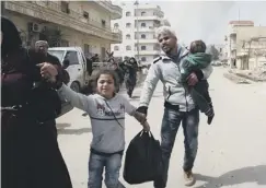  ??  ?? 0 Civilians run for cover from explosions in Afrin yesterday