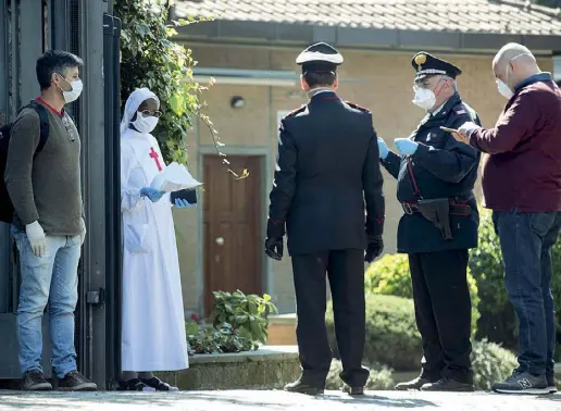  ??  ?? Carabinier­i nell’istituto «Figlie di San Camillo» di Grottaferr­ata dove 40 suore sono risultate positive al coronaviru­s