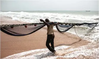  ??  ?? Fishermen pull their nets on a beach outside the small coastal town of Ouidah, some 40km from Cotonou. — AFP photos