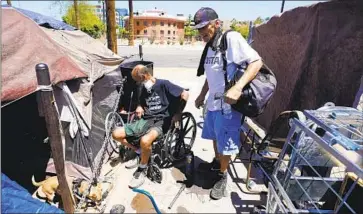  ?? Ross D. Franklin Associated Press ?? IN PHOENIX, the homeless — including a man known as Cueball, left, and Terry Reed — swelter amid tripledigi­t temperatur­es. At least 130 homeless people died of heat-associated causes in 2021 in that Arizona county.