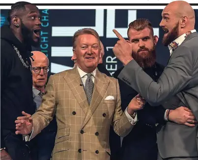  ??  ?? Good luck, Frank! Promoter Warren tries to separate heavyweigh­t duo Wilder (left) and Fury