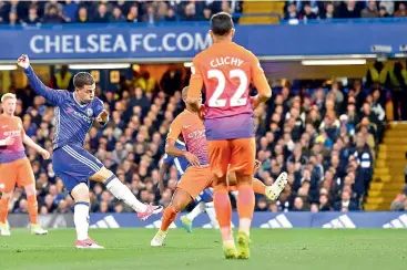  ??  ?? Chelsea’s Eden Hazard (left) scores against Manchester City in their English Premier League match at Stamford Bridge in London on Wednesday. Chelsea won 2-1.