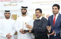 ??  ?? Sheikh Humaid bin Ammar Al Nuaimi receives a memento during the inaugurati­on of Thumbay Elite Clinic in Ajman.