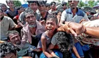  ?? Reuters ?? A boy is pulled to safety as Rohingya refugees scuffle while queueing for aid at Cox’s Bazar, in Bangladesh. —