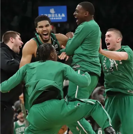  ?? NAncy lAne / HerAld stAff ?? GARDEN PARTY: Jayson Tatum celebrates with his Celtics teammates after hitting a buzzer-beating winning shot in a 115-1114 victory in Game 1 of their first round series against the Brooklyn Nets at the TD Garden Sunday.