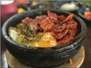  ?? PHOTO COURTESY OF MARY ORLIN ?? At Oakland’s Bowl’d BBQ, a bowl of Sizzling Works Dolsot Bibimbap arrives at the table topped with spicy pork belly, 13 vegetables, a fried egg and plenty of spicy gochujang.