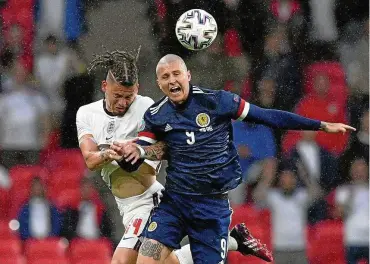  ?? FOTO: JUSTIN TALLIS / DPA ?? Zweikampf um den Ball bei strömendem Regen: Englands Kalvin Phillips (links) attackiert den schottisch­en Gegenspiel­er Lyndon Dykes.