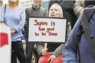  ??  ?? Longtime customer Fanny Renoir holds a sign in support of Caffe Sapore in North Beach.