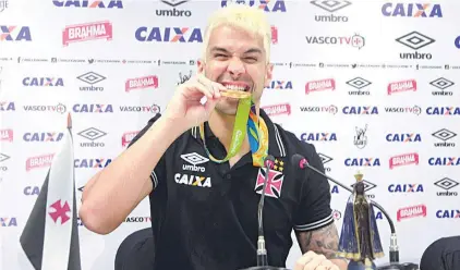  ?? PAULO FERNANDES/VASCO.COM.BR ?? De visual novo, Luan morde a medalha de ouro que ganhou nos Jogos do Rio: só lesão no joelho o preocupa