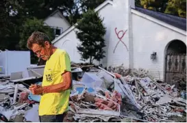  ?? Yi-Chin Lee / Houston Chronicle ?? Contractor Ricky Green of Alabama finishes a day of picking up large debris in a Memorial-area neighborho­od. A red X signifying that someone died inside still marks Robert Arthur Haines’ house on Langwood.