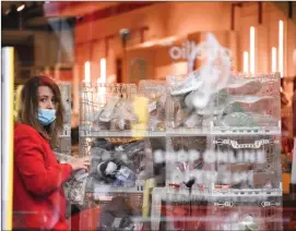  ?? Associated Press photo/Alberto Pezzali ?? A store staff member works to prepare the shop for reopening, ahead of the reopening of the non-essential businesses, as some of the coronaviru­s lockdown measures were eased Friday in London. The British economy shrank by a colossal 20.4 per cent in April, the first full month that the country was in its coronaviru­s lockdown.