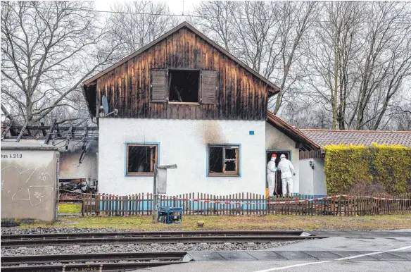 ?? FOTO: CHRISTIAN FLEMMING ?? Spurensuch­e in der Eichwaldst­raße: Bereitscha­ftspolizis­ten inspiziere­n das ausgebrann­te Bahnwärter­haus.