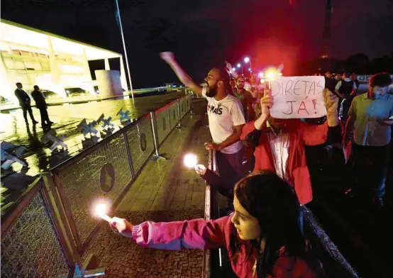  ?? Pedro Ladeira/Folhapress ?? Na praça dos Três Poderes, em frente ao Palácio do Planalto, manifestan­tes pedem saída de Temer e convocação de eleições diretas, ontem à noite