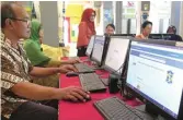  ?? SEPTINDA AYU/JAWA POS ?? PERSIAPAN: Tim Panitia PPDB SMPN 19 mempersiap­kan fasilitas pendaftara­n online jalur kawasan kemarin.