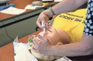  ?? MICHAEL SEARS / MILWAUKEE JOURNAL SENTINEL ?? Lee Clay demonstrat­es administer­ing Narcan on a dummy during training.