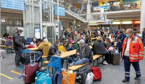  ?? FOTO: MICHAEL REICHEL / DPA ?? Die Flüchtling­e aus der Ukraine werden von Helfern betreut und warten kurz nach der Ankunft des Flugzeuges aus Chișinău im Gebäude des Flughafens Erfurt. Sie werden wenig später in Bussen in drei Landkreise gebracht.
