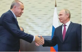  ?? AFP ?? Top, a man uses a pickaxe to dig a cave in the Syrian village of Kafr Ain in Idlib on Saturday in anticipati­on of an assault by regime forces. Above, Russian President Vladimir Putin, right, shakes hands with Turkish President Recep Tayyip Erdogan during their meeting in Sochi yesterday in which a deal was struck to avert an offensive against the rebel-held province